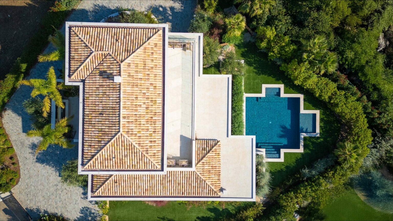 Villa contemporaine aux toits de tuiles et piscine en croix, vue zénithale
